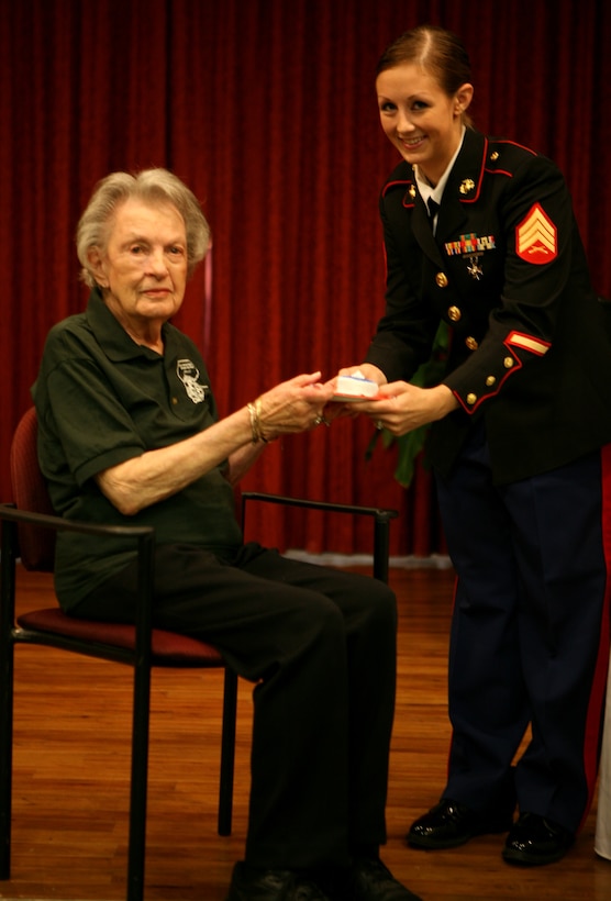 Brenlie Wilson, a former sergeant and the youngest present member of the Molly Marine Chapter LA-1, Women Marines Association, passes a piece of cake to Marian Y. Landry, also a retired sergeant and the oldest member of the Chapter. (Photo by: Pfc. Jessica DeRose)