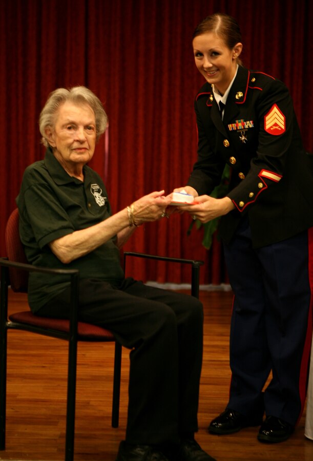 Brenlie Wilson, a former sergeant and the youngest present member of the Molly Marine Chapter LA-1, Women Marines Association, passes a piece of cake to Marian Y. Landry, also a retired sergeant and the oldest member of the Chapter. (Photo by: Pfc. Jessica DeRose)