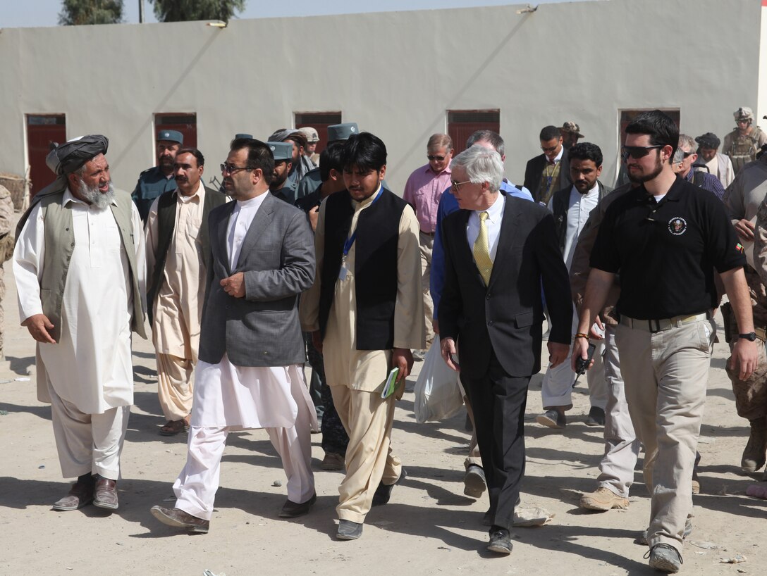 Nawa District Governor Abdul Manaf (far left) gives a tour of a local bazaar to Ambassador Ryan Crocker, U.S. Ambassador to Afghanistan, (second from right)  here, Oct. 31. Crocker used the visit as an opportunity to see firsthand the progress Afghan security forces and the district government are making in Nawa. “We have been pleased to be your partners in security and economic support, but the real reason for the success here is all of you,” Crocker said in an address to local district leaders and residents.  Your courage and commitment to make this community and district a better place is what accounts for the success.”  During the ambassador's visit, Manaf highlighted plans for Nawa's future, emphsizing his enduring objectives of peace, poppy eradication, education and security.