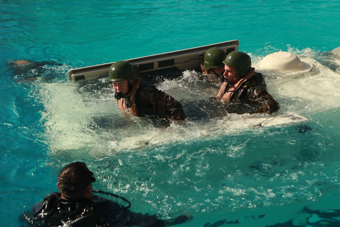 Marines with the 11th Marine Expeditionary Unit practice evacuating a sinking amphibious assault vehicle here Nov. 7. Approximately 200 Marines and sailors with Company L, 11th Marine Expeditionary Unit, made the Corps’ first egresses from a simulated amphibious assault vehicle, which was dunked in a Pendleton pool Nov. 7-11. The Marines embarked USS Makin Island, USS New Orleans and USS Pearl Harbor in San Diego Nov. 14 beginning a seven-month deployment to the western Pacific and Middle East regions.::r::::n::