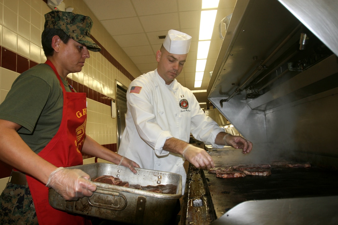 First Sgt. Brenda R. Chrismer (left), from Edinburg, Texas, the Food Service Company first sergeant, Combat Logistics Regiment 27, 2nd Marine Logistics Group, and Capt. David F. Trunley (right), from Columbia, S.C., the commanding officer of Food Service Company, cook steaks for a Marine Corps’ birthday lunch celebration aboard Camp Lejeune, N.C., Nov. 8, 2011.  During the event food service Marines prepared steak and lobster, as well as a cake for everyone attending the lunch. (Photo by Cpl. Bruno J. Bego)