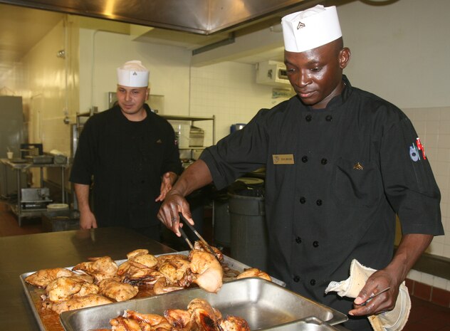 Cpl. Essohouna Tegbede, from Moline, Ill., a food service specialist with Combat Logistics Regiment 27, 2nd Marine Logistics Group, prepares chicken for a Marine Corps’ birthday lunch celebration aboard Camp Lejeune, N.C., Nov. 8, 2011.  During the event food service Marines prepared steak and lobster, as well as a cake for everyone attending the lunch. (Photo by Cpl. Bruno J. Bego)