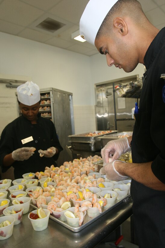 Pfc. Rolchelle J. Chase (background), from Easton, Md., and Cpl. Cristian B. Rodriguez, from Paterson, N.J., food service specialists with Combat Logistics Regiment 27, 2nd Marine Logistics Group, prepare shrimp cocktail for a Marine Corps’ birthday lunch celebration aboard Camp Lejeune, N.C.,  Nov. 8, 2011.  During the event food service Marines prepared steak and lobster, as well as a cake for everyone attending the lunch. (Photo by Cpl. Bruno J. Bego)