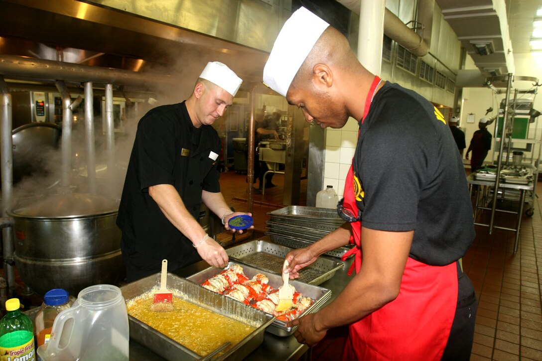 Cpl. Ryan D. Rumsey (left), form Hillsdale, Mich., a food service specialist, and Gunnery Sgt. Morris Mayfield III (right), from New Orleans, the food service liaison for Mess Hall 521, both with Combat Logistics Regiment 27, 2nd Marine Logistics Group, prepare lobsters for a Marine Corps’ birthday lunch celebration aboard Camp Lejeune, N.C., Nov. 8, 2011.  During the event food service Marines prepared steak and lobster, as well as a cake for everyone attending the lunch. (Photo by Cpl. Bruno J. Bego)