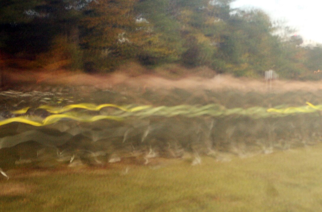 Marines and sailor with the 2nd Marine Logistics Group jog past during the 2nd MLG Marine Corps Birthday run aboard Camp Lejeune, N.C., Nov. 8, 2011. The run was in honor of the Corps’ 236th birthday and was followed by a traditional cake-cutting ceremony at Soifert Field. (U.S. Marine Corps photo by. Pfc. Franklin E. Mercado)