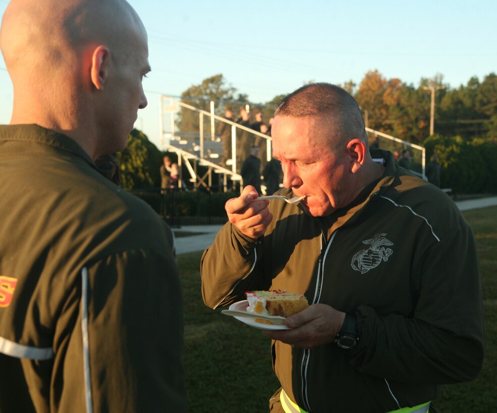Master Gunnery Sgt. John H. Wilbur, the oldest Marine with the 2nd Marine Logistics Group, eats the first piece of cake during a cake-cutting ceremony at Soifert Field aboard Camp Lejeune, N.C., Nov. 8, 2011. During Marine Corps cake-cutting ceremonies, it is tradition for the oldest and youngest Marine to have the first piece of cake. (U.S. Marine Corps photo by Pfc. Franklin E. Mercado)