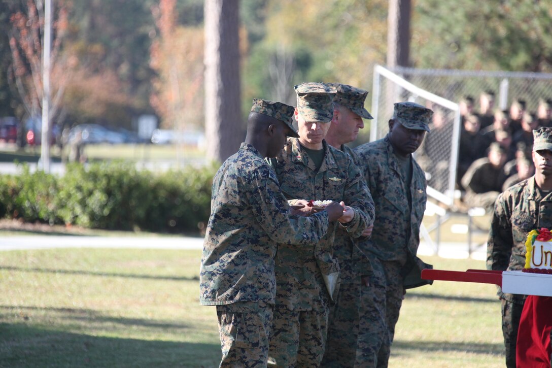 Lance Cpl. Charles Guthrie, left, takes the second piece of cake from the oldest Marine present, Chief Warrant Officer 3 James R. Walls, center, during the 236th Marine Corps Birthday Cake-cutting Ceremony and Historical Uniform Pageant in front of the Christian F. Schilt building Nov. 8. Guthrie was the youngest active duty Marine present at the ceremony and enlisted into the Marine Corps in 2010, while Walls enlisted in 1991.