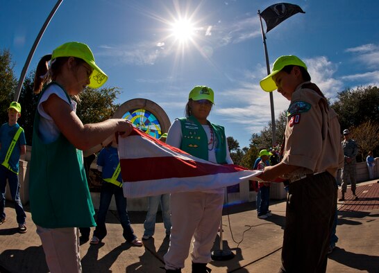 Girl and boy scouts fold the flag during a Veterans Day ceremony at the All Wars Memorial at Eglin Air Force Base, Fla., Nov. 8.  (U.S. Air Force photo/Sachel Seabrook)