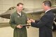 Jeff Babione, vice president and program manager for Lockheed-Martin's F-22 Raptor program, presents Lt. Col. David Piffarerio, 302nd Fighter Squadron commander, with a plaque and patch to commemorate his 1,000 flight hour in the F-22 Raptor. Piffarerio is the first pilot to reach this milestone during a sortie Nov. 4.  (U.S. Air Force Photo/ Capt. Ashley Conner)
