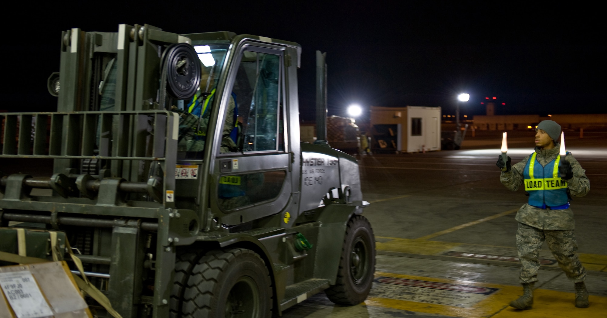YOKOTA AIR BASE, Japan -- Airman 1st Class Abraham Olalde, 374th Maintenance Squadron aerospace propulsion journeyman, operates a forklift with the help of Senior Airman Quron Witherspoon, 374th Logistics Readiness Squadron petroleum, oil and lubricant journeyman, at Yokota Air Base, Japan, Nov. 9, 2011. The two squadrons often work together to move cargo and equipment throughout the Pacific region. (U.S. Air Force photo/Airman John D. Partlow)