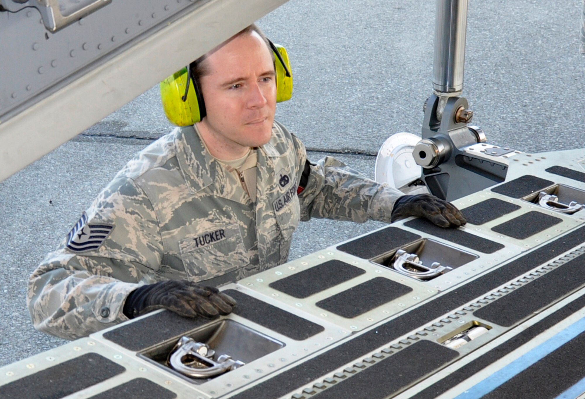 Tech. Sgt. Johnation Tucker, 86th Aerial Port Squadron, McChord Field, Wash., makes sure the ramp is clear on a C-17 Globemaster III before loading pallets, Nov. 8, 2011. Tucker hails from Everett, Wash. and works as a logistics supervisor with Philips Electronics in Seattle. The joint airlift inspector, who?s been with the 446th AW since 2007, has been deployed three times. His most recent was at Balad Air Base, Iraq in 2009. (U.S. Air Force photo/Master Sgt. Jake Chappelle)