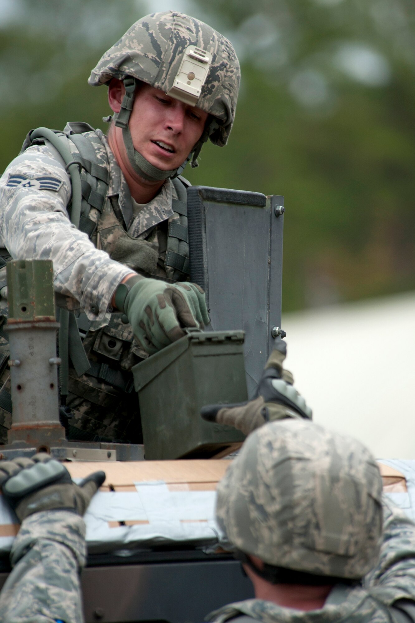 U.S. Air Force Senior Airman Timothy Cranston, 307th Security Forces Squadron, hands an ammo box to one of his teammates from the top of a Humvee turret during the Mental and Physical (MAP) competition during Global Strike Challenge, Barksdale Air Force Base, La., Nov. 7, 2011. The timed event required the team to unload and stack 24 filled ammo cans. (U.S. Air Force photo by Master Sgt. Greg Steele/Released)