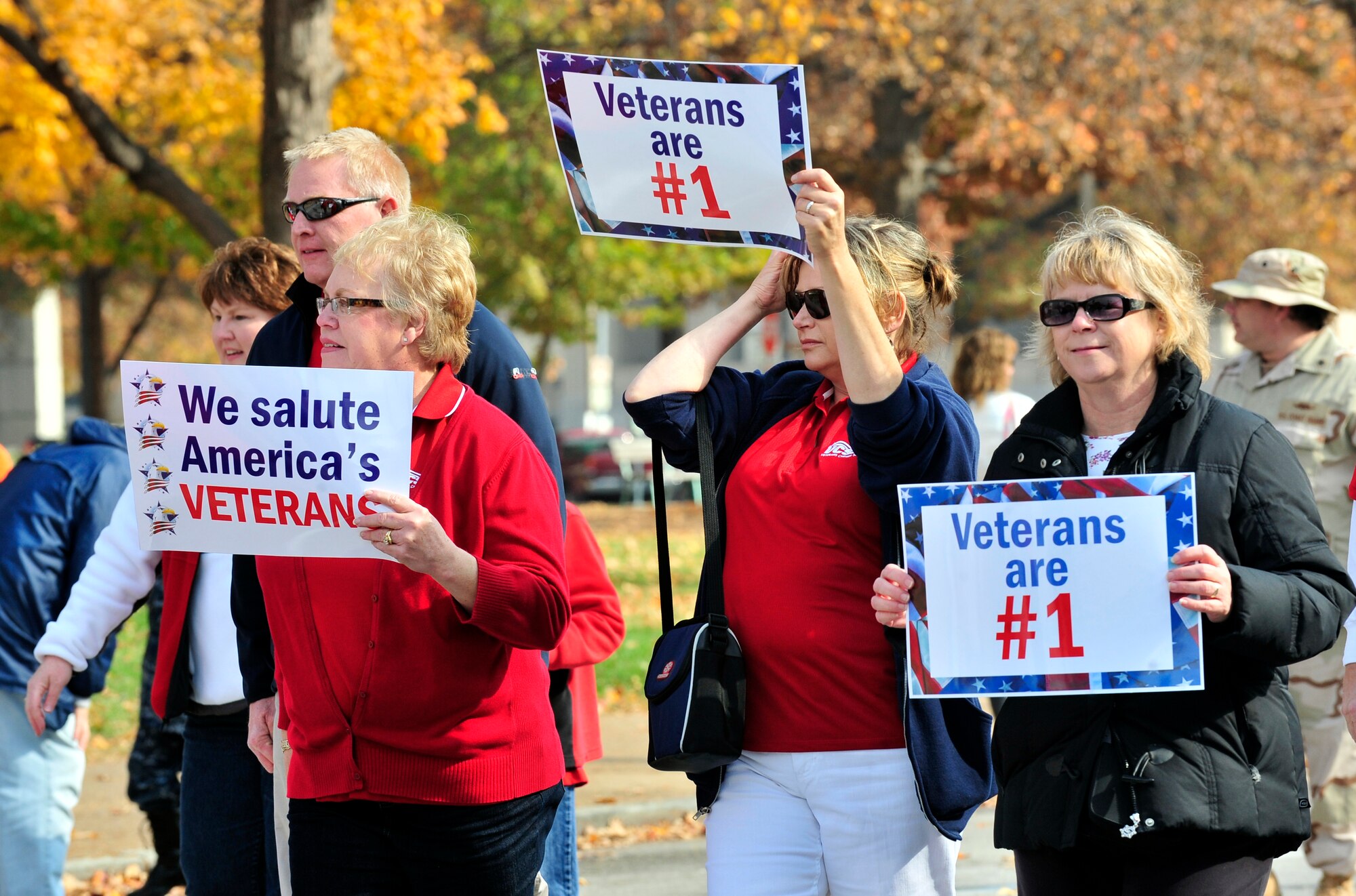Civilian participants and family members march while holding up signs expressing their feelings toward veterans. The parade featured representatives from all services. (U.S. Air Force photo/ Staff Sgt. Stephenie Wade)