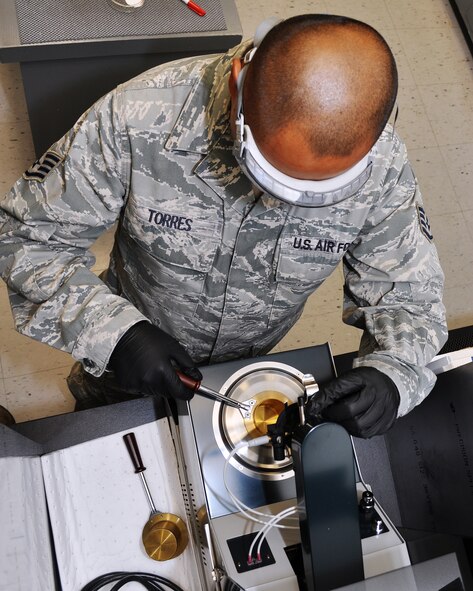 U.S. Air Force Staff Sgt. Dale Torres, 9th Logistics Readiness Squadron fuels technician, prepares the flash point tester at the Beale Air Force Base, Calif., Fuels Lab, Nov. 8, 2011. The machine determines the fuel's response to heat and ignition, which ensures that it will ignite at the appropriate temperature.  (U.S. Air Force photo by Staff Sgt. Jonathan Fowler)