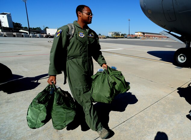 Staff Sgt. Kevin Sumlin carries bags that will be loaded onto the aircraft before a mission at Joint Base Charleston - Air Base Nov. 2.  Flying Crew Chiefs are trained in many specialized aircraft maintenance skills and provide universal support as the lone maintainer to fix most aircraft issues that may occur during a flying mission. Sumlin is a flying crew chief with the 437th Aircraft Maintenance Squadron.  (U.S. Air Force photo/ Staff Sgt. Nicole Mickle)  