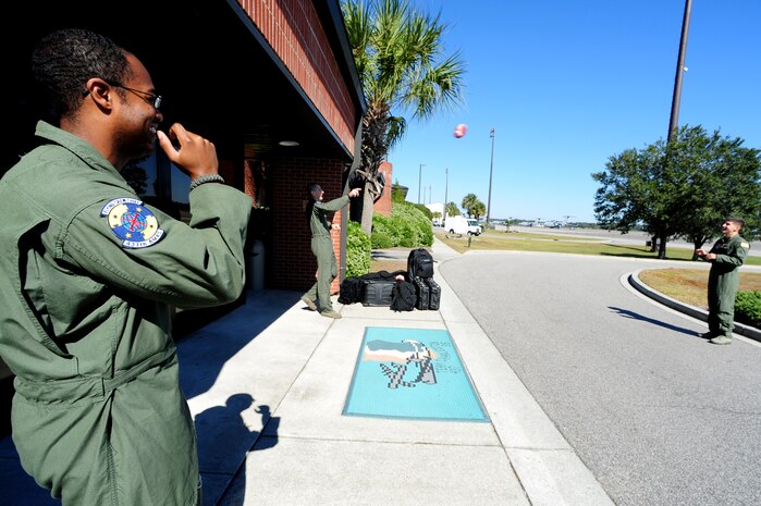 Staff Sgt. Kevin Sumlin tosses a football around with Security Forces Phoenix Raven's from McDill Air Force Base while waiting for transportation to their aircraft at Joint Base Charleston - Air Base Nov. 2.  Flying Crew Chiefs were trained in many specialized aircraft maintenance skills and provide universal support as the lone maintainer to fix most aircraft issues that may occur during a flying mission.  Sumlin is a flying crew chief with the 437th Aircraft Maintenance Squadron.  (U.S. Air Force photo/ Staff Sgt. Nicole Mickle)   