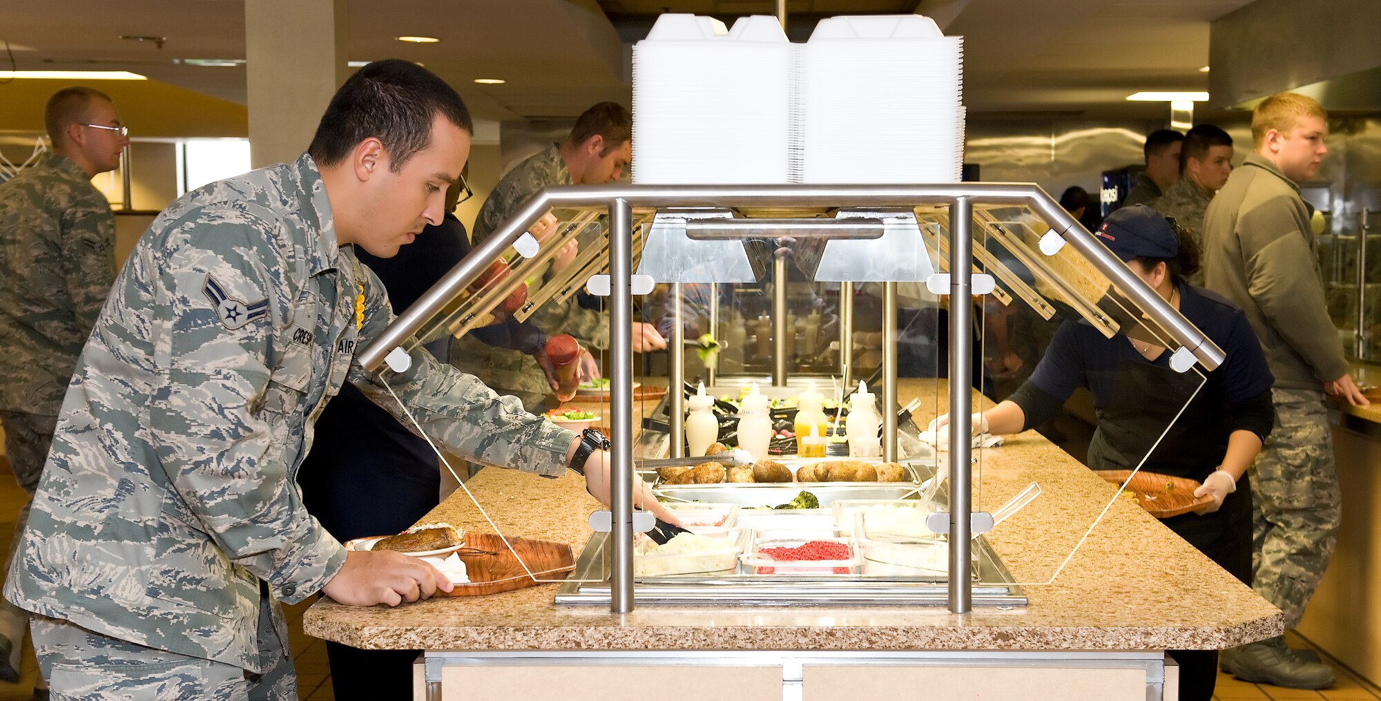 Airman 1st Class Kevin Crespo, a C-5 crew chief with the 373rd Training Squadron, dishes up food from the new salad bar Nov. 7, 2011, at the Dover Air Force Base, Del., Patterson Dining Facility. The DFAC recently underwent an extensive three-week rennovation, including a new salad bar, themed seating areas and an expanded serving area. (U.S. Air Force photo by Roland Balik)
