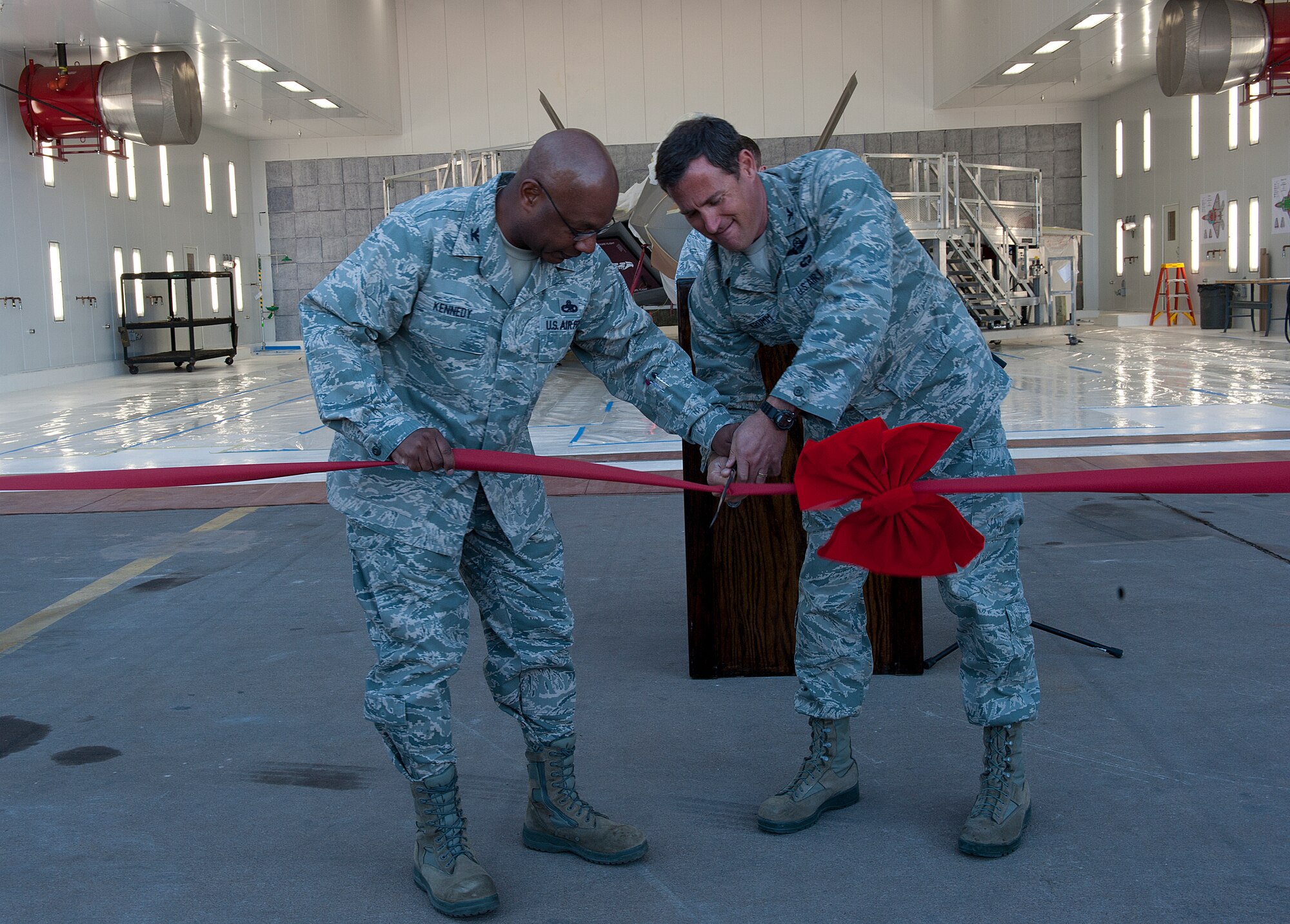 HOLLOMAN AIR FORCE BASE, N.M. -- U.S. Air Force Col. David Krumm, 49th Wing commander, and U.S. Air Force Col. André Kennedy, 49th Maintenance Group commander, cut a ribbon Nov. 2, 2011, during the dedication and ribbon cutting of the new Low Observatory hangar. The new facility will allow 49th MXG Airmen to repair the LO coating of an aircraft in a more timely manner. (U.S. Air Force photo by Senior Airman DeAndre Curtiss / Released)