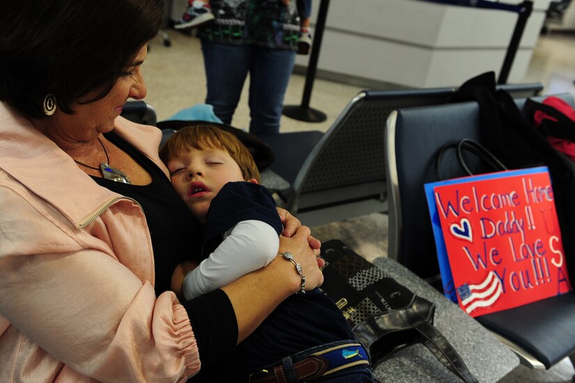 Sulliven Damron falls asleep while waiting for his father,  Maj. John Damron to return from a 120-day deployment to Southwest Asia at Joint Base Charleston - Air Base, Nov. 5. More than 130 Airmen from the 14th Airlift Squadron, 437th Airlift Wing deployed to the 816th Expeditionary Airlift Squadron supporting combat operations in the U.S. Central Command area of responsibility. Flying the C-17 Globemaster III, the 14 AS Airmen flew roughly 2,800 sorties, logged more than 7,900 combat flying hours and airlifted more than 27,000 Airmen, Soldiers, Marines and distinguished visitors throughout the AOR. The squadron also performed 382 airdrops, delivering 16.7 million pounds of cargo to 52 drop zones, breaking the record for deployed C-17 combat operations.  Damron is a pilot with the 14 AS.  (U.S. Air Force photo/ Staff Sgt. Nicole Mickle 