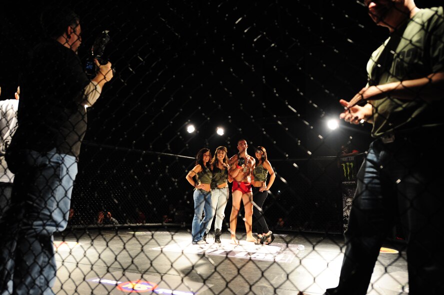 Tommy DiBernardo poses for a victory photo with the Fight Lab ring girls after his match in the 916th Air Refueling Wing’s corrosion control hangar on Seymour Johnson Air Force Base, N.C., Nov. 4, 2011. DiBernardo’s match proved to be a tough call for the judges when they were not able to come to a unanimous decision on the winner. DiBernardo specializes in wrestling and Ju Jitsu and is a native of Ponton, N.J. (U.S. Air Force photo by Senior Airman Rae Perry)