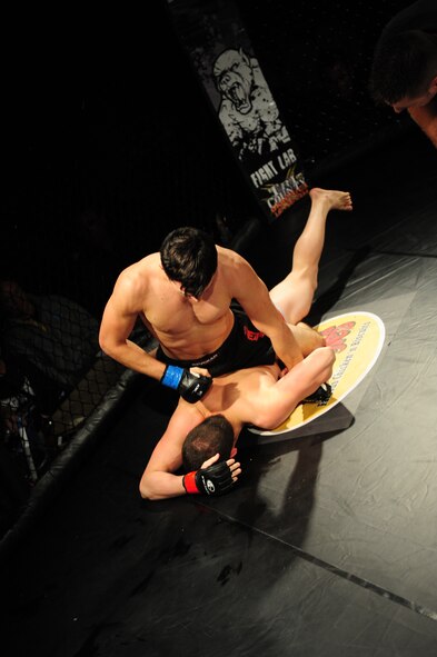 Jared Miller pummels James Tate after pinning him to the floor of the ring during a mixed martial arts (MMA) fight in the 916th Air Refueling Wing's corrosion control hangar on Seymour Johnson Air Force Base, N.C., Nov. 4, 2011. The fight went three rounds but ended when Tate tapped out after being put into a full body lock. Miller specializes in MMA fighting and is a native of Fuquay-Varina, N.C., and Tate specializes in boxing and hails from Gastonia, N.C. (U.S. Air Force photo by Senior Airman Rae Perry)