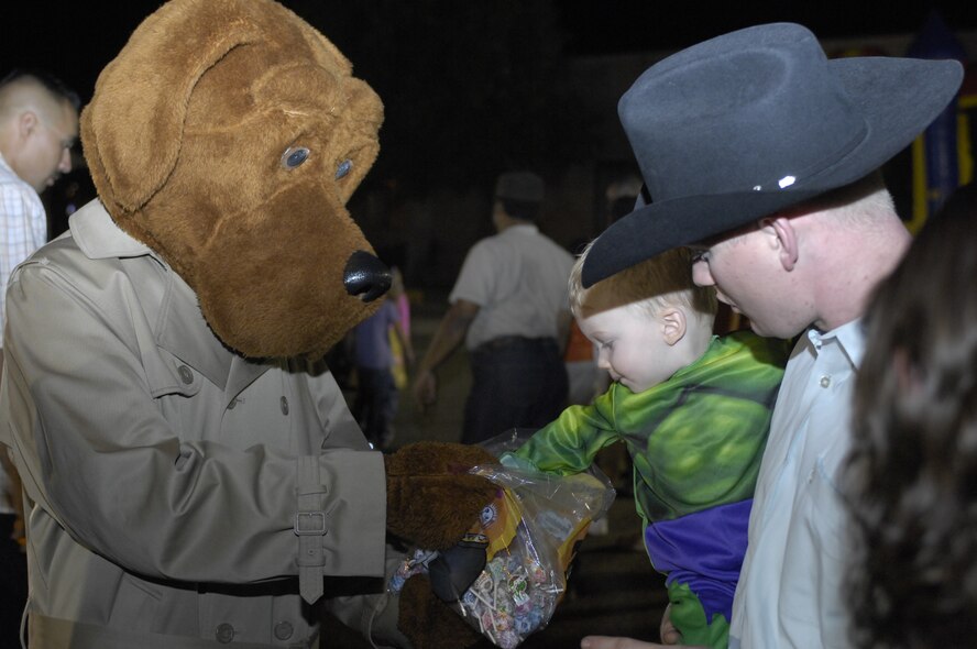 Braxton Simmons, 1, receives candy from McGruff the crime dog while waiting for a pony ride at Hallelujah Night at Luke Air Force Base, Ariz., Oct 28, 2011. Children and Families were treated to a night of food, games and live entertainment at the Luke Chapel. (U.S. Air Force photo by Staff Sgt. Jason Colbert/Released)