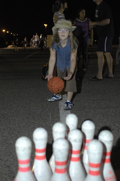 Emma Chestnut, 6, tries to knock over pens with a basket ball at Hallelujah Night, Luke Air Force Base, Ariz., Oct 28, 2011. Games, food and live entertainment were provided to all participants of this annual event held by the Luke Chapel. (U.S. Air Force photo by Staff Sgt. Jason Colbert/Released)