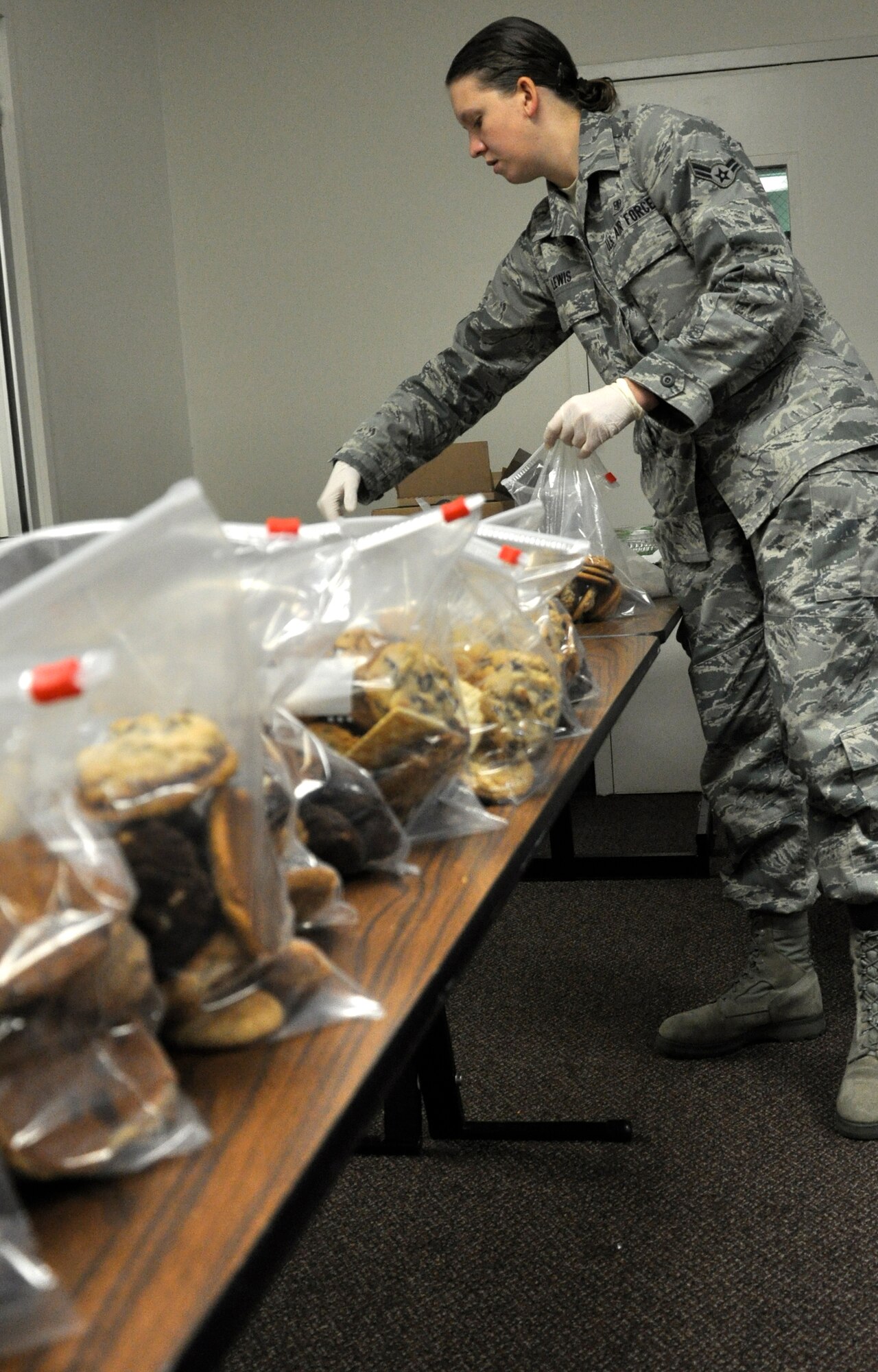 Volunteers baked and bagged lots of cookies for shipment to deployed Airmen from Vance Air Force Base, Okla., Nov. 3 at the Community Chapel Activity Center. Airman 1st Class Lydia Lewis, a dental technician with the 71st Medical Operations Squadron at Vance, seals bags of cookies before loading into boxes for mailing. (U.S. Air Force photo/ Airman 1st Class Frank John Casciotta)