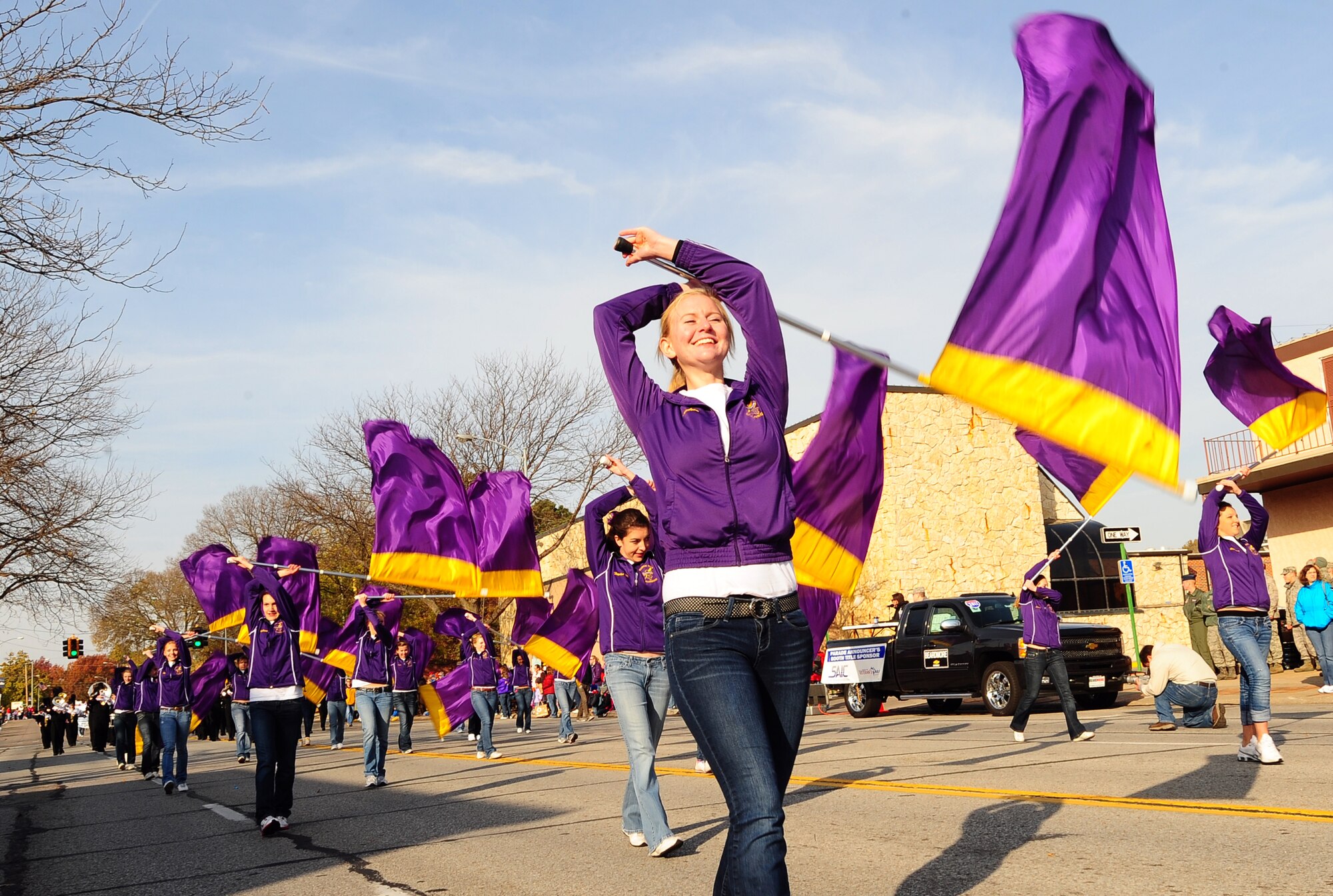 The Bellevue West High School marching band's flag corps marches through the heart of Bellevue, Neb. as they participate in the 2011 Veterans Day parade, Nov. 5.  .  Hundreds of military members start the annual parade where people gather to pay their respects to those who serve in the armed forces. (U.S. Air Force photo by Josh Plueger/Released)