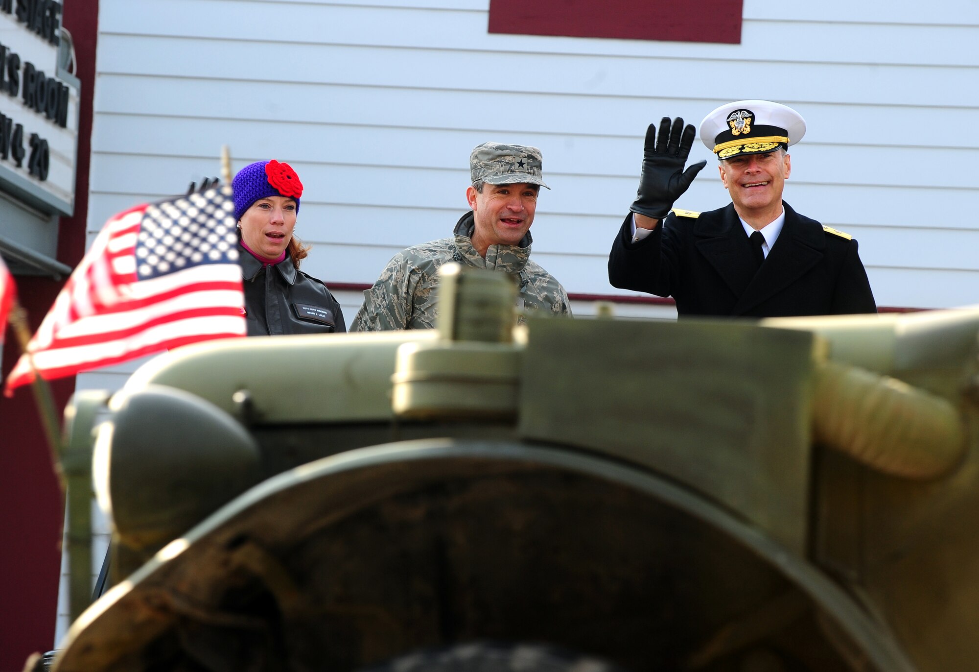 Megan Lucas, Bellevue Chamber of Commerce, Brig. Gen. Donald Bacon, 55th Wing commander, and Rear Adm. Fritz Roegge, Joint Functional Component Command for Global Strike at U.S. Strategic Command, stand on the grand stand and salute the veterans as they march down Mission Ave. in Bellevue, Neb., Nov. 5.  The city of Bellevue has always maintained a very close and supportive role with the Offutt community. (U.S. Air Force photo by Josh Plueger/Released)