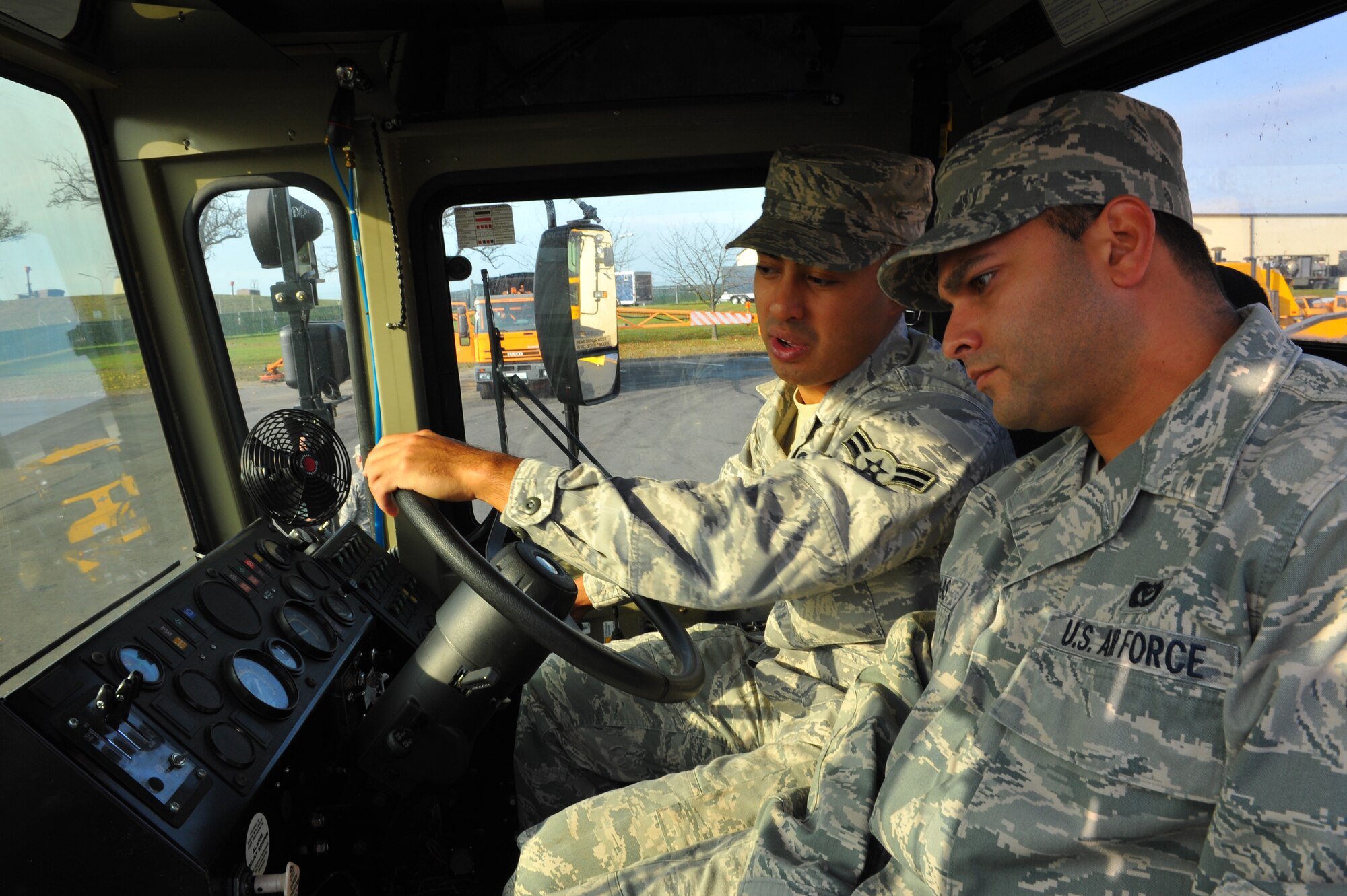 SPANGDAHLEM AIR BASE, Germany – Senior Airman Siegmar Vargas, 52nd Civil Engineer Squadron water fuels maintenance journeyman, teaches Airman 1st Class Kyle Albrecht, CES heavy equipment apprentice, how to safely operate the front blade on a snow plow during annual snow-control augmentee training here Nov. 8. The 52nd CES snow-control team completes annual mandatory training before they can be licensed to operate and maintain snow-removal vehicles used during winter. The team assigns 33 permanent augmentees and 10 alternate augmentees from Nov. 14 to April 15 each year for the snow season. (U.S. Air Force photo/Airman 1st Class Dillon Davis)