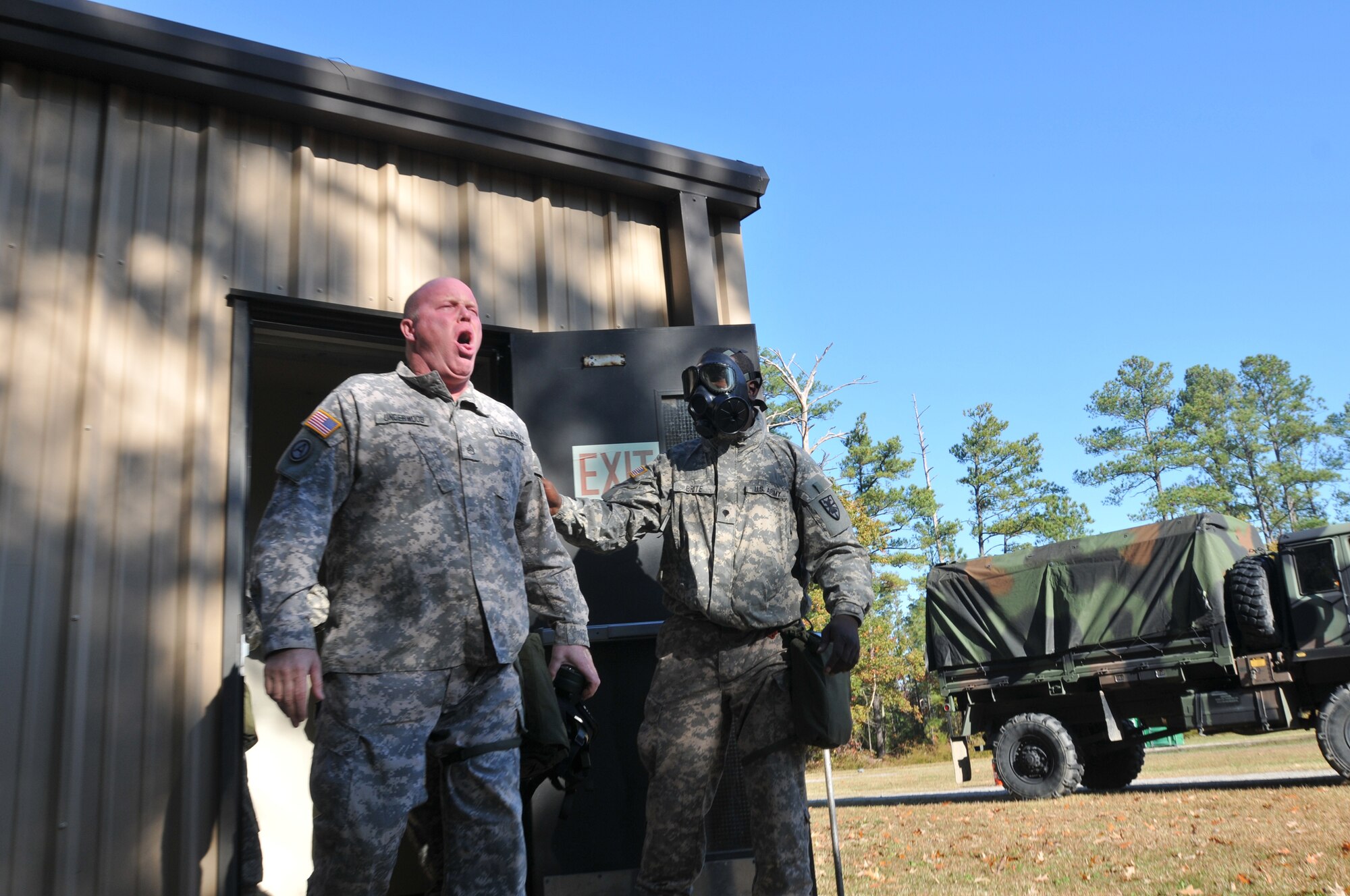 Staff Sgt. Tim Underwood (left), operations NCO in charge, 331st Transportation Company, 24th Trans. Battalion, 7th Sustainment Brigade, experiences the effect of the gas chamber during the unit’s Chemical, Biological, Radiological and Nuclear training session Wednesday morning at Training Area 26 at Fort Eustis. (U.S. Army photo by Pfc. Alex Kilmon/RELEASED)