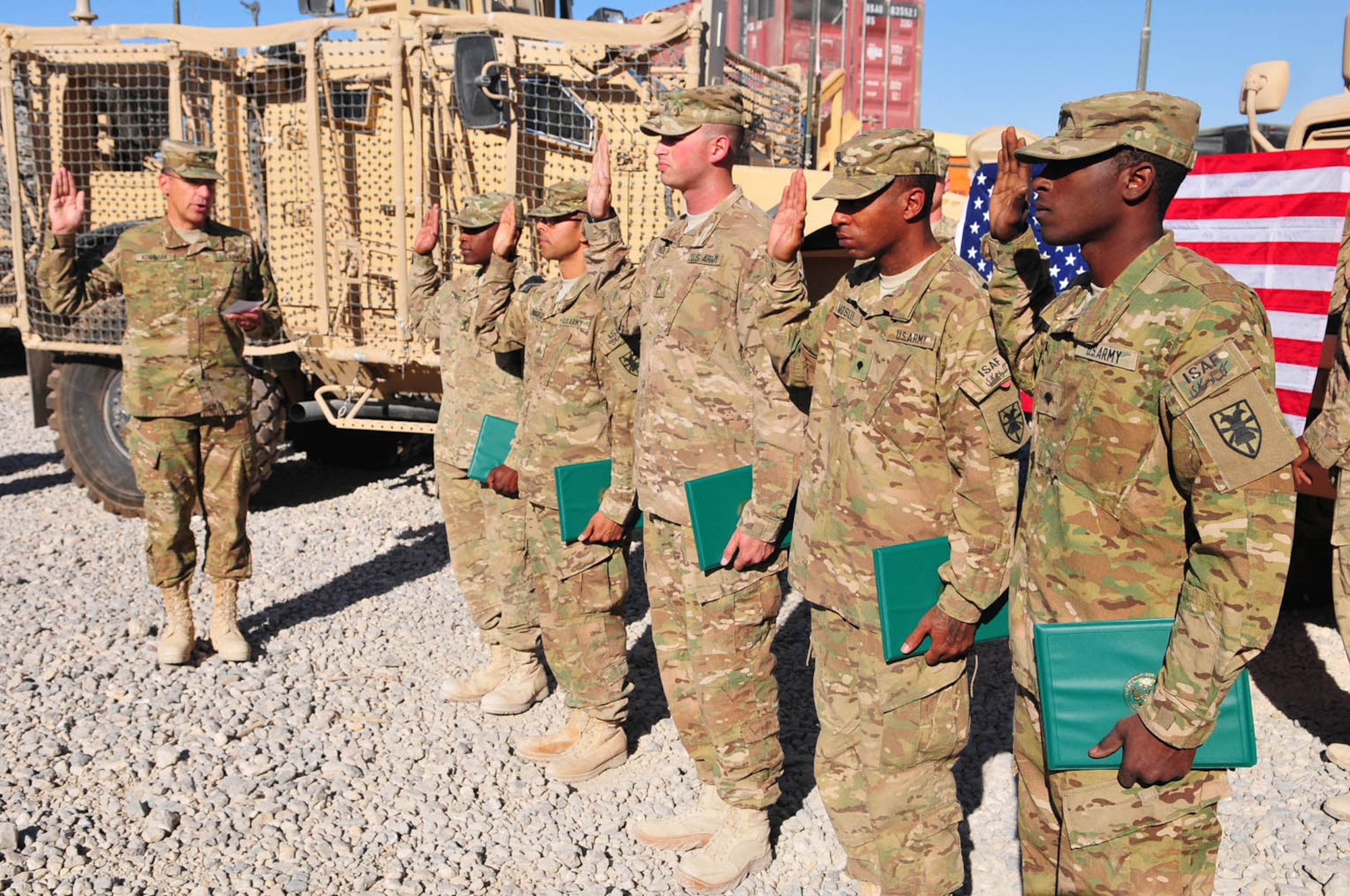 Col. Lawrence Kominiak, left, Task Force Resolute commander, issues the oath of enlistment to, from left, Spc. Ashford Turner, Sgt. Edwin Rodriguez, Sgt. Phillip Spiniao, Spc. Rashaun Moseley, and Spc. Elmore Young III, during a mass reenlistment ceremony at the Headquarters and Headquarters Company, Special Troops Battalion, TF-Resolute motorpool at Kandahar Airfield, Afghanistan, Oct. 24. (U.S. Army photo Staff Sgt. Alexander Burnett/RELEASED)