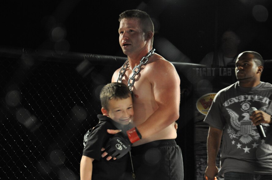 Kevin Kenna Sr., a mixed martial arts (MMA) fighter, hugs his son after winning his fight during an MMA cage fight on Seymour Johnson Air Force Base, N.C., Nov. 7, 2011. Kenna’s son supports his father by calling him into the ring every fight. Kenna trains in Goldsboro, N.C., and is a soldier stationed at Fort Bragg in Fayetteville, N.C. (U.S. Air Force photo by Airman 1st Class Mariah Tolbert)
