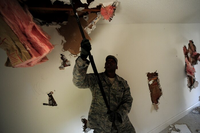 Technical Sgt. Rudolph Stuart creates a hole in a ceiling for a team member to climb through to gain access to another room during Close Quarters Battle Training at Joint Base Charleston - Air Base Nov. 1. CQB training prepares security forces personnel to handle hostage situations or a threat that is within close range. Stuart is with the 628th Security Forces Squadron.  (U.S. Air Force photo/ Staff Sgt. Nicole Mickle)