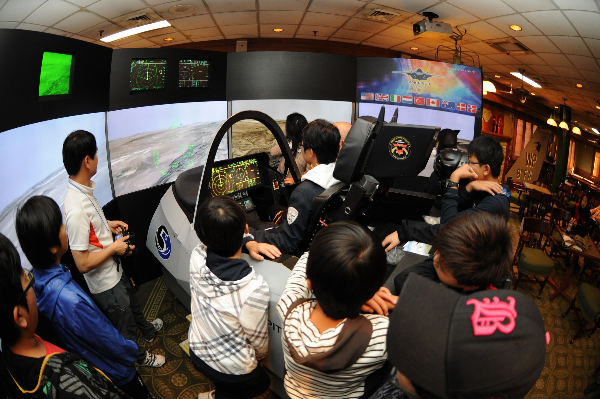 A student participating in the 8th Fighter Wing Honorary Pilot Program takes the 5th generation F-35 Lightning II trainer cockpit for a spin at Kunsan Air Base, Republic of Korea, Nov. 4, 2011. The program gave students a glance of what an F-16 pilot?s life is like here at Kunsan. They were able to receive a tour of an F-16 static display, F-35 Lighting II simulation, tour of the base tower, tower simulation, 35th Fighter Squadron tour and participated in hands on activities. (U.S. Air Force photo by Senior Airman Brittany Y. Auld/Released)
