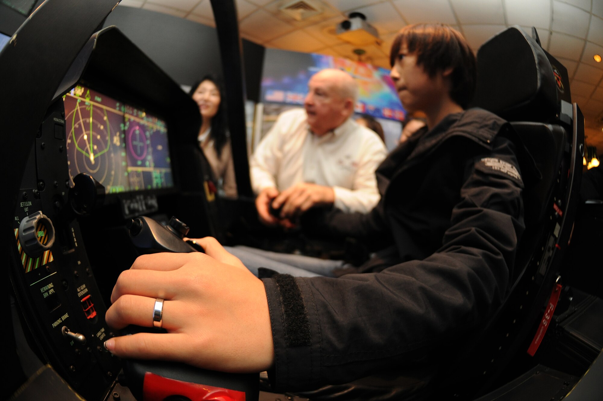 A student participating in the 8th Fighter Wing Honorary Pilot Program takes the 5th generation F-35 Lightning II trainer cockpit for a spin at Kunsan Air Base, Republic of Korea, Nov. 4, 2011. The program gave students a glance of what an F-16 pilot?s life is like here at Kunsan. They were able to receive a tour of an F-16 static display, F-35 Lighting II simulation, tour of the base tower, tower simulation, 35th Fighter Squadron tour and participated in hands on activities. (U.S. Air Force photo by Senior Airman Brittany Y. Auld/Released)
