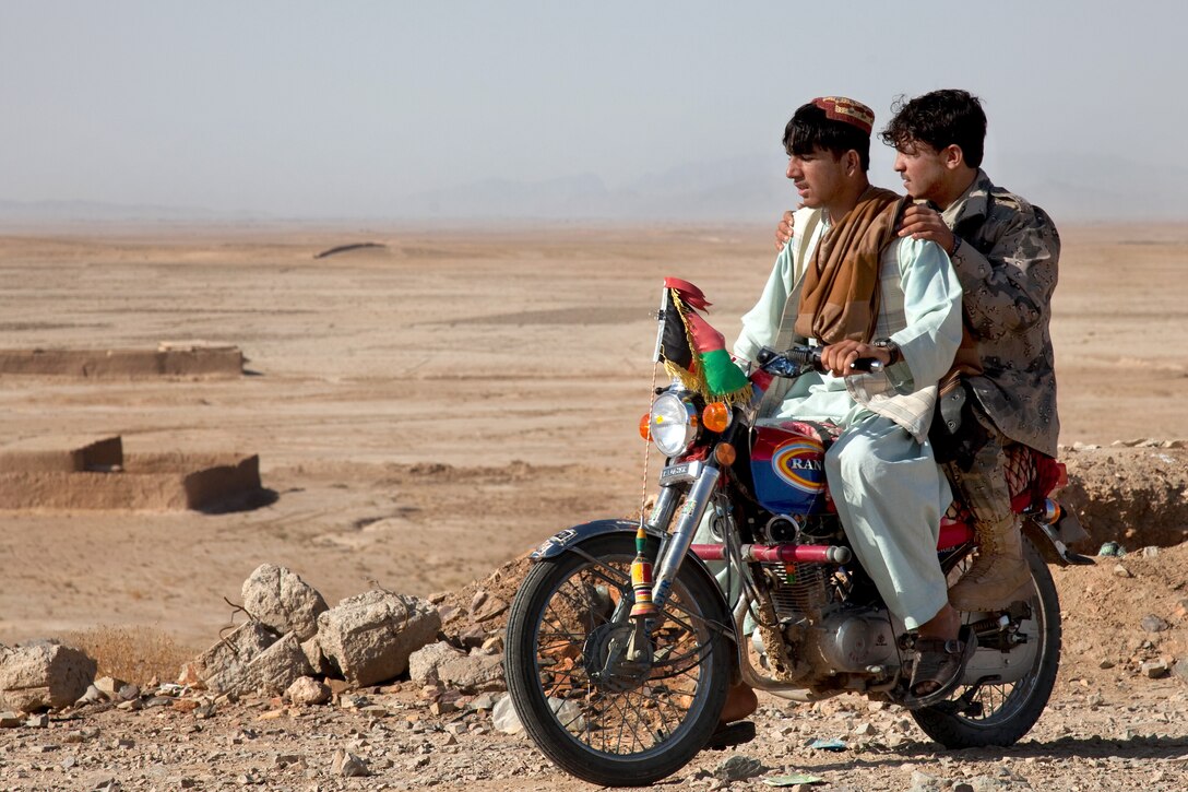 Afghan police officers leave for patrol on a motorcycle at Checkpoint 64 outside Loy Karez in Kandahar province, Afghanistan, Nov. 2, 2011.