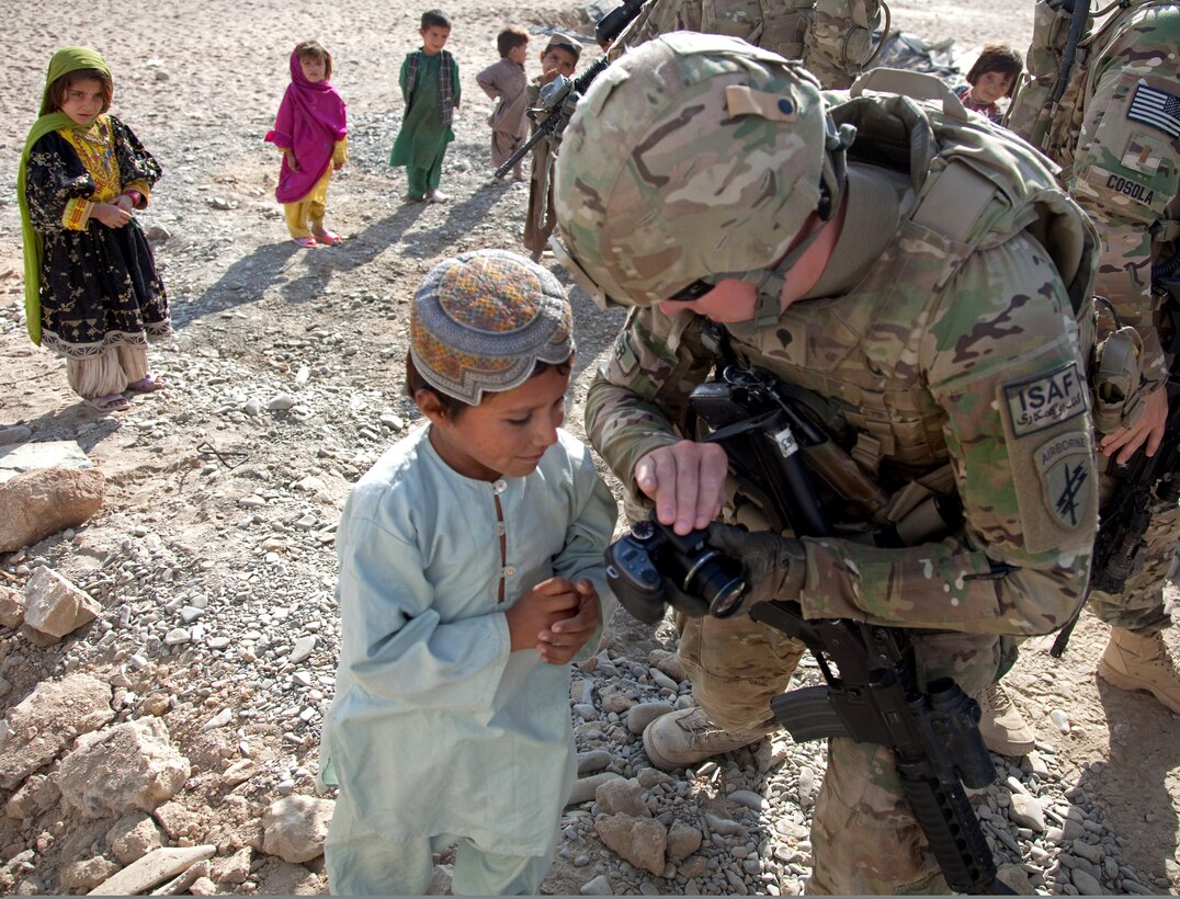 U.S. Army Spc. Matthew Oliver takes pictures with Afghan children near Forward Operating Base Spin Boldak in Kandahar province, Afghanistan, Nov. 4, 2011. Oliver is assigned to the 504th Battlefield Surveillance Brigade.