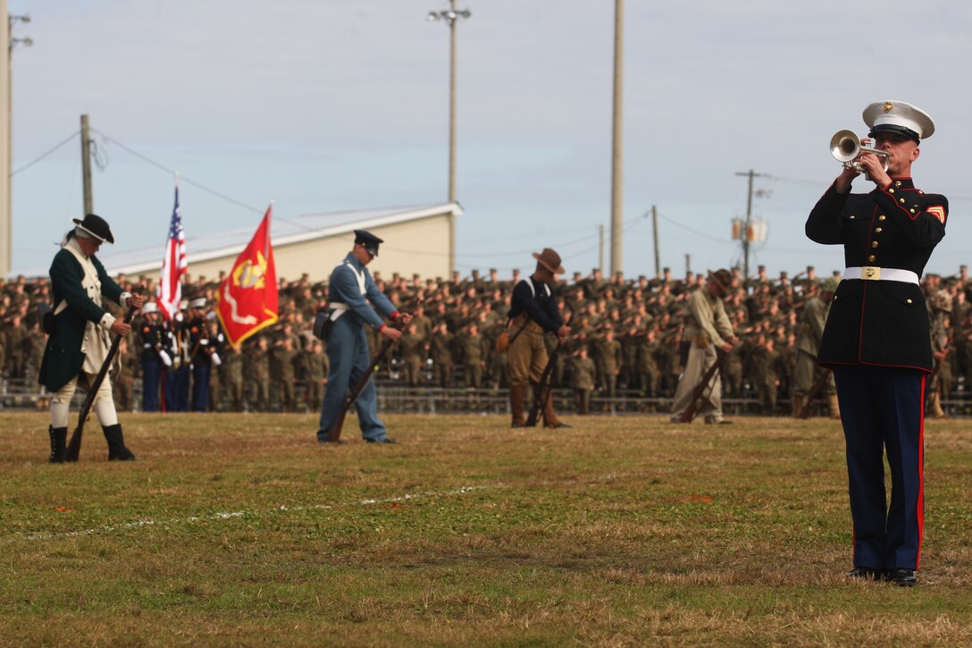 Marines clad in various uniforms spanning the Marine Corps' history stand with bowed heads as taps is played during the 2011 Joint Daytime Ceremony aboard Marine Corps Base Camp Lejeune, Nov. 9. Showcasing a cake-cutting ceremony amidst columns of Marines in a multitude of uniforms spanning the centirues since 1775, service members and civilians alike were treated to a succinct telling of the Marine Corps' history.