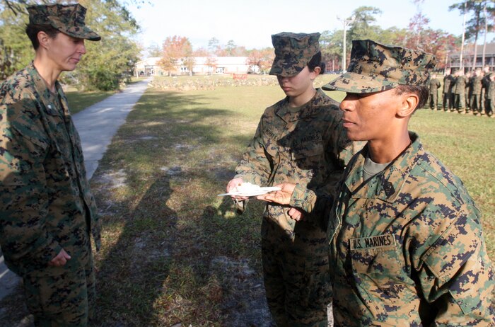 Sgt. Maj. Stephanie K. Murphy (right), a Pine Bluff, Ark., native, the battalion sergeant major and the oldest Marine present, passes a piece of cake to the youngest Marine, Lance Cpl. Christiana C. Morales (middle), a ground radio operator, both with Combat Logistics Battalion 2, Combat Logistics Regiment 2, 2nd Marine Logistics Group during a cake cutting ceremony aboard Camp Lejeune, N.C., Nov. 9, 2011.  After a six-mile hike and other physical training exercises, the Marines enjoyed a traditional cake cutting ceremony to celebrate the Marine Corps’ 236th birthday. (Photo by Cpl. Bruno J. Bego)