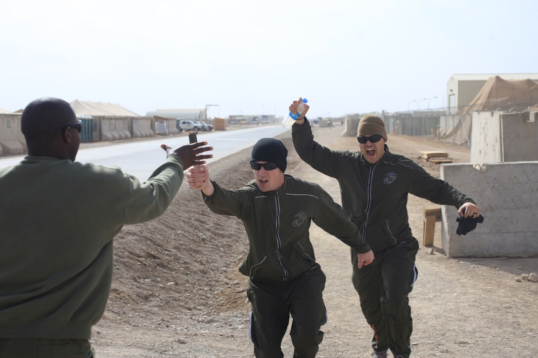 From left to right, Sgt. Adrian Howard takes the baton from Cpl. Ryan Bennett and Cpl. Rene Granados at Camp Leatherneck, Afghanistan, Nov. 9. The Marines, deployed with Marine Air Support Squadron 1, are taking part in the Chieftain Run. Every year the squadron conducts a run in 30-minute shifts for 24 hours straight to honor fallen brethren.