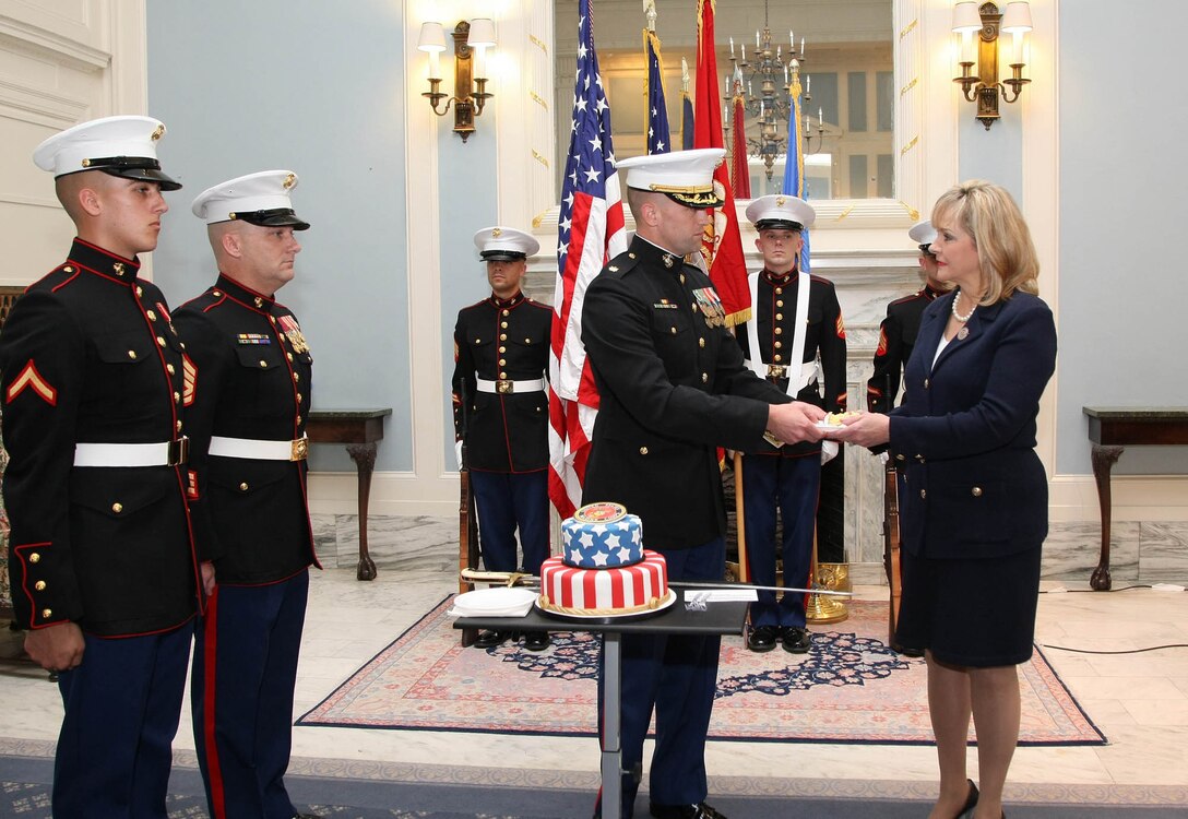 Maj. Richard Robinson, III, commanding officer of Marine Corps Recruiting Station Oklahoma City, (center) hands a piece of cake to the guest of honor, Oklahoma Governor Mary Fallin during the cake cutting ceremony commemorating November as "Marine Month" in the state of Oklahoma, at the state capitol here, Nov. 9.