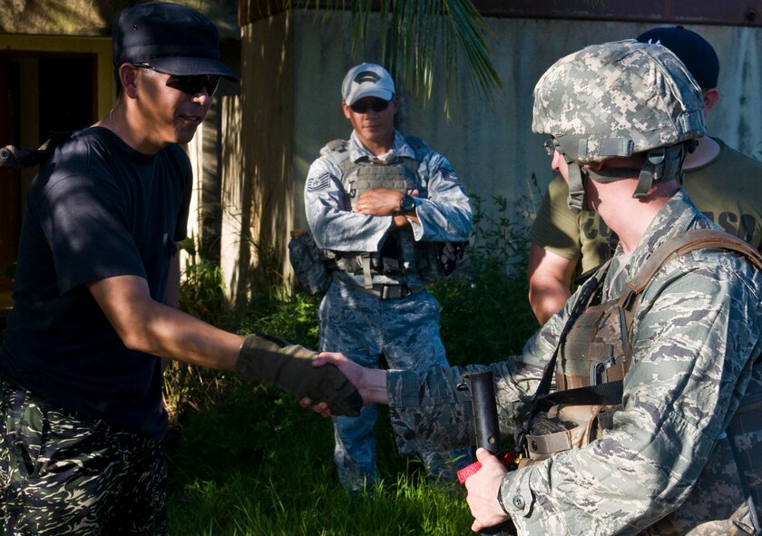 ANDERSEN AIR FORCE BASE, Guam—A member of the opposing force shakes hands with Capt. Joseph Eanett (right), 35th Security Forces Squadron operations officer from Misawa Air Base, Japan, during a training scenario at the Pacific Air Forces Regional Training Center here, Nov. 7. Members of the 736th Security Forces Squadron Commando Warrior Flight ran several different scenarios to allow trainees to practice for real world actions and reactions.(U.S. Air Force photo by Senior Airman Benjamin Wiseman/Released)