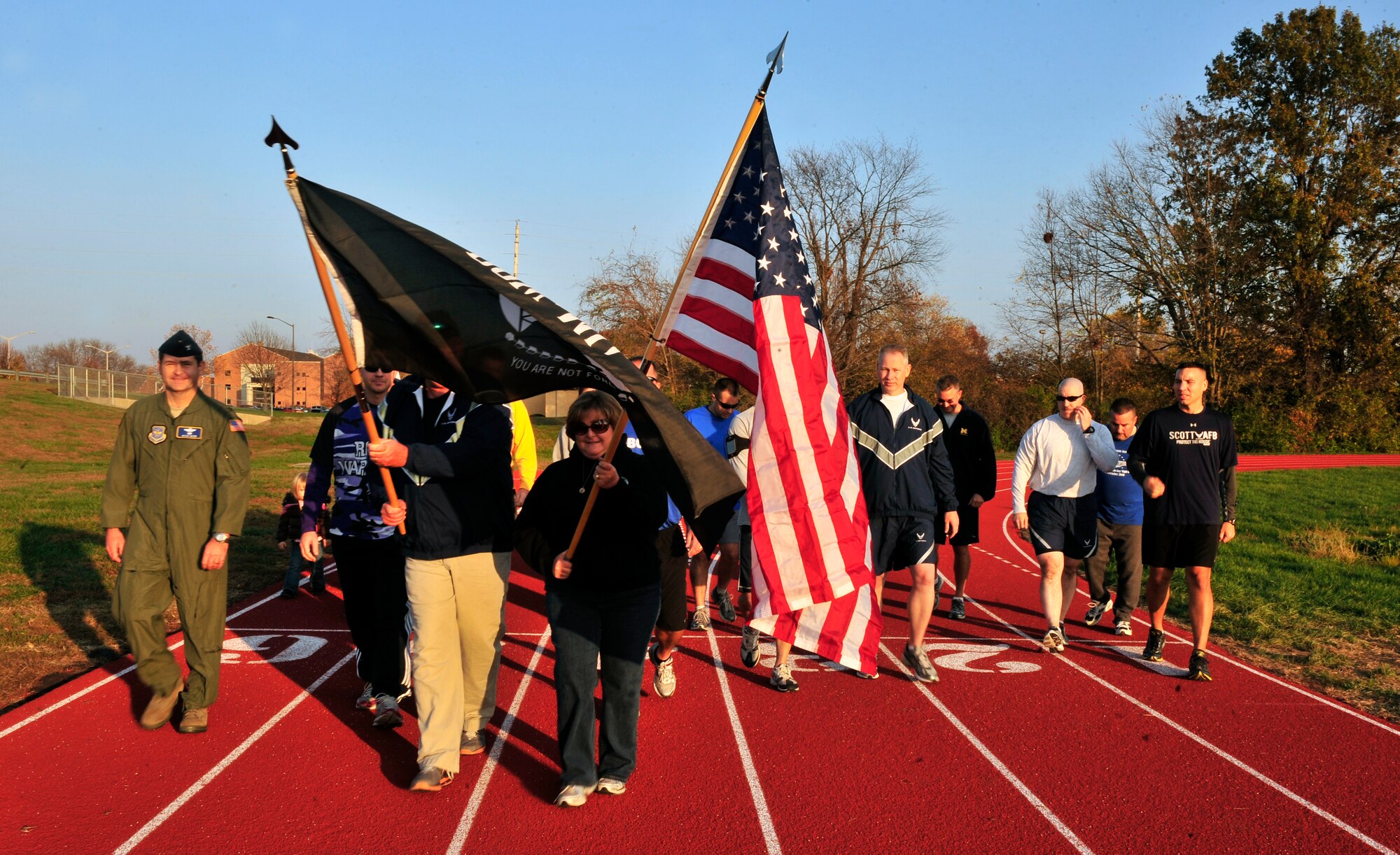Paula and Gary Smith walk the first lap around the track on Scott AFB, Ill Nov. 4 carrying the American flag and POW/MIA flag during the 24-hour Air Force Sergeants Association Veterans Day Vigil relay run honoring their son Senior Airman Bradley Smith from Troy, Ill. Bradley Smith was killed in action in January 2010. The vigil candle lit in honor of veterans past and present burned for the 24 hours relay.  (United States Air Force photo/ Staff Sgt. Stephenie Wade)