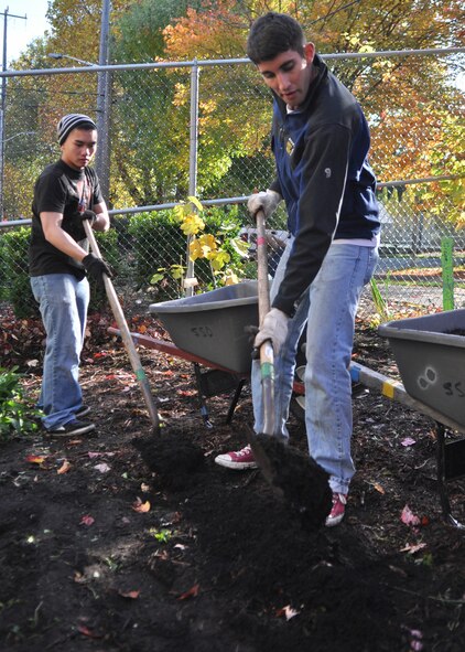 Two Airmen from McChord Field shovel mulch and create a path for children to walk through the garden at Madrona School Nov. 5, 2011, in Seattle. (U.S. Air Force photo/Airman 1st Class Leah Young)