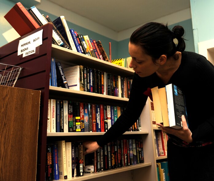 MINOT AIR FORCE BASE, N.D. -- Shanya Hughes, Airman’s Attic bookkeeper, arranges books as part of her volunteer duties at the Airman’s Attic. The Airman’s Attic has traditionally been a venue where Airmen and their families can go to and attain uniform attire including other miscellaneous items for free. The Airman’s Attic is open Mondays and Wednesdays from 10 a.m. to 2 p.m. and Thursdays from 5 p.m. to 7 p.m. (U.S. Air Force Photo/Airman 1st Class Stephanie Ashley)
