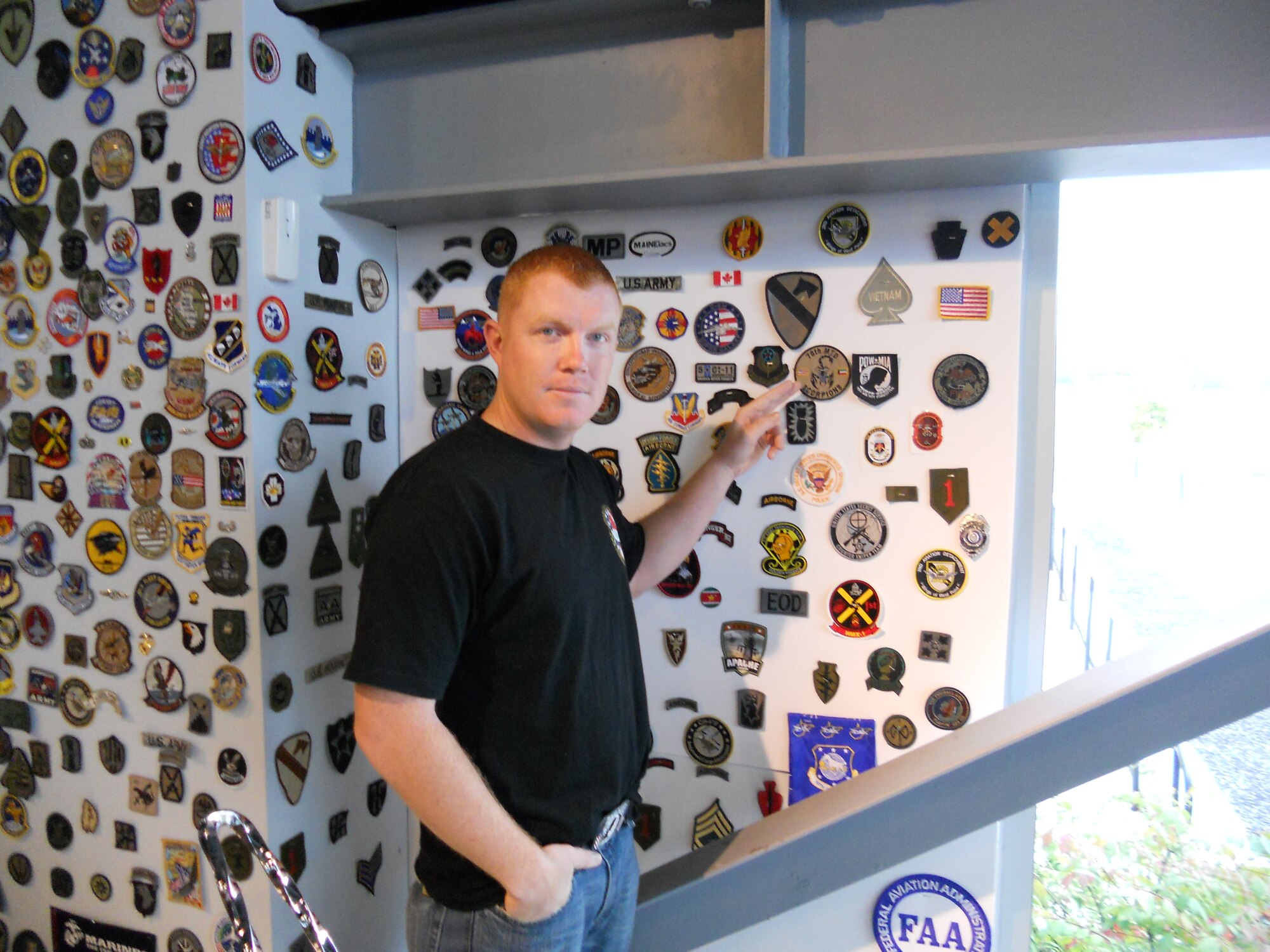 While visiting Paul Jr. Designs in Rock Tavern, N.Y., Staff Sgt. Patrick Mackey, 366th Logistics Readiness Squadron quality assurance inspector, points at a unit patch Sept. 27, 2011. Mackey was invited to Paul Jr. Designs after presenting the reality television star and custom motorcycle designer Paul Jr. Teutal with an American flag flown at 14 locations throughout Iraq. (Courtesy photo)