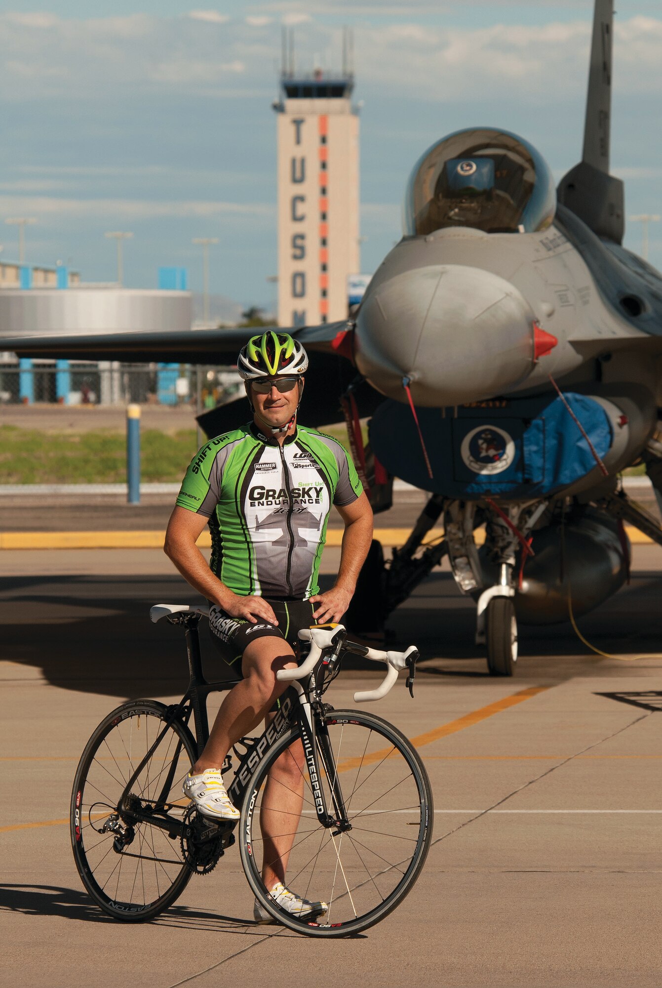 Maj. Brian Grasky, an F-16 Fighting Falcon instructor pilot, highlights his role as an Arizona Air National Guardsman as well as his off-duty role as a triathlon coach on the 162nd Fighter Wing flightline at Tucson International Airport. Grasky is among several avid cyclists featured in a new book, Tucson Spokes, about the city’s cycling scene. (Courtesy photo by Chris Mooney)