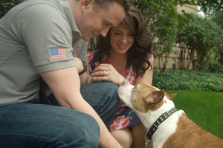 Former Senior Airman David Sharpe and his wife, Jenny, share a family moment with their dog Cheyenne outside their home Sept. 22, 2011, in Arlington, Va. Sharpe is the founder of Pets 2 Vets, a nonprofit organization that pairs shelter animals with veterans. Sharpe came up with the idea for P2V after he realized how Cheyenne’s companionship helped him deal with traumatic events he went through while deployed to Saudia Arabia. (U.S. Air Force photo/Tech. Sgt. Mareshah Haynes)